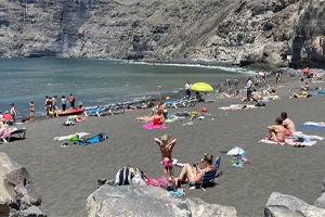 En esta foto vemos a gente tomando el sol en la playa de Los Guios en Los Gigantes