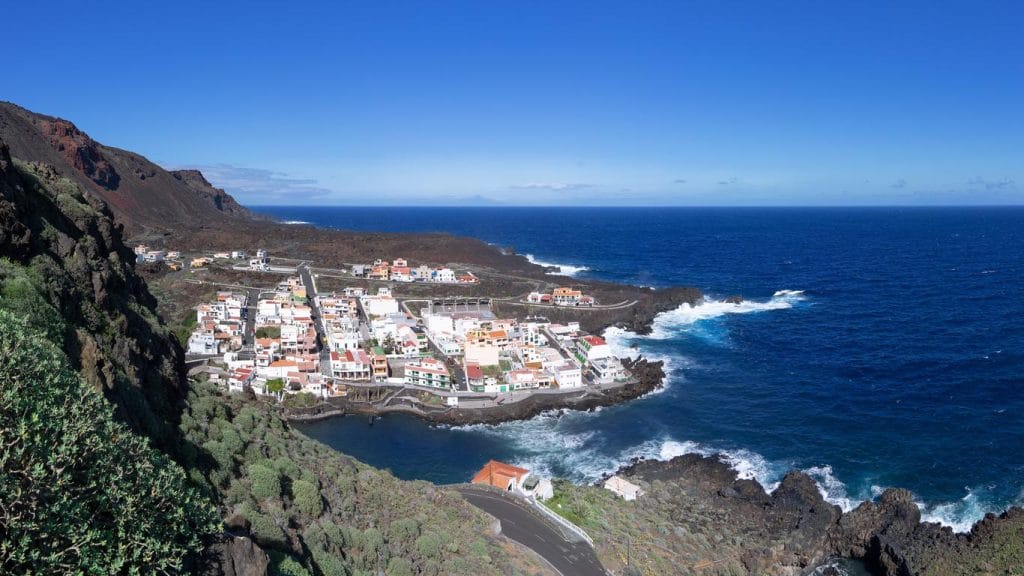 Valverde panoramica Pueblo costero de Valverde con casas blancas rodeado de montañas y mar azul, paisaje natural y urbano.
